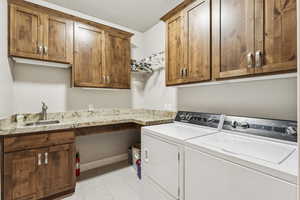 Washroom with light tile patterned floors, separate washer and dryer, and cabinet space