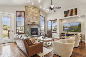 Living room featuring wood-type flooring, a fireplace, ceiling fan, high vaulted ceiling, and recessed lighting