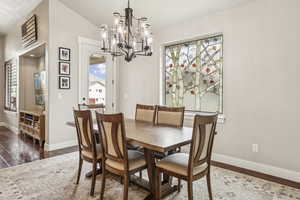 Dining room featuring dark wood-style floors and a chandelier