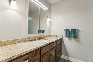 Half bathroom with vanity and baseboards