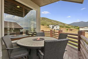 Balcony featuring a fire pit, a deck with mountain view, and outdoor dining space