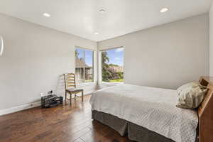 Bedroom with dark wood-style floors and recessed lighting