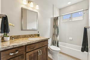 Bathroom with shower / bathtub combination with curtain, vanity, and light tile patterned floors