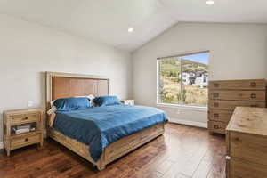 Bedroom featuring dark wood-style floors, lofted ceiling, and recessed lighting