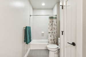 Bathroom featuring shower / bath combo with shower curtain and toilet