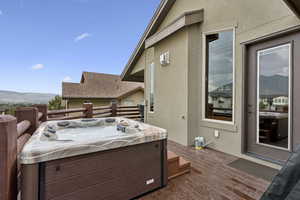 Wooden deck featuring a mountain view and a hot tub