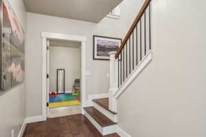 Foyer featuring stairs and dark wood-type flooring