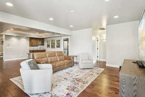 Living area featuring recessed lighting, a tray ceiling, and dark wood finished floors