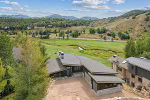 Aerial view of property and surrounding area with mountains and a golf club