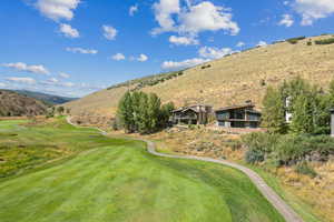 View from above of property with a golf club and a mountain backdrop