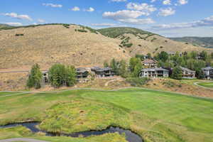 View of mountain backdrop with a golf course and a large body of water