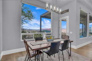 Dining room with a mountain view, light wood-style floors, and a chandelier
