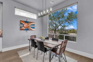 Dining room featuring light wood-style flooring, a mountain view, and a chandelier