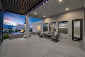 Patio terrace at dusk featuring a patio area and an outdoor living space with a fire pit