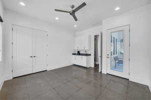 Unfurnished bedroom featuring a ceiling fan, recessed lighting, dark tile patterned flooring, and access to outside