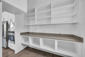 Kitchen featuring appliances with stainless steel finishes, dark wood-style flooring, and white cabinets