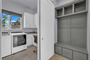 Laundry room featuring cabinet space, separate washer and dryer, and light tile patterned flooring