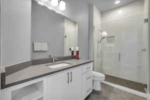 Bathroom featuring vanity, a shower stall, and light tile patterned floors