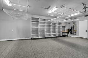 Garage with baseboards and secured water heater