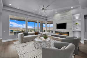 Living area with wood finished floors, recessed lighting, built in shelves, a fireplace, and a ceiling fan