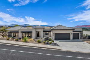 Prairie-style house featuring a mountain view, a garage, stucco siding, driveway, and a tile roof
