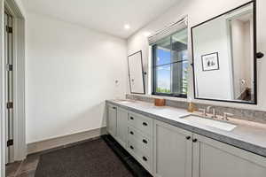 Full bath with double vanity, dark tile patterned flooring, and recessed lighting