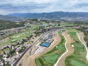 Aerial overview of property's location with a golf club and a water and mountain view