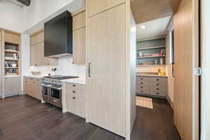 Kitchen featuring light brown cabinetry, open shelves, built in features, and range with two ovens
