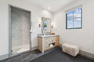 Full bathroom with a marble finish shower, vanity, dark tile patterned flooring, and recessed lighting