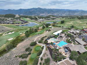 Aerial view of property's location featuring a golf course and a water and mountain view