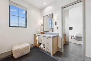 Ensuite bathroom with vanity, dark tile patterned floors, and recessed lighting
