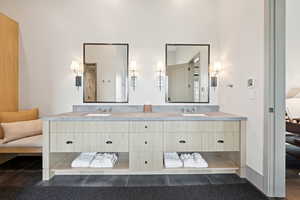 Ensuite bathroom with double vanity and dark tile patterned floors