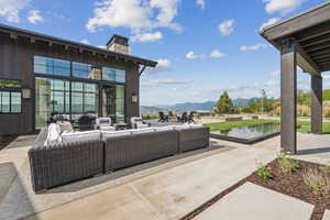 View of patio / terrace featuring an outdoor hangout area and a water and mountain view