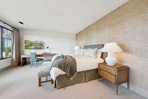 Bedroom with wallpapered walls, light colored carpet, recessed lighting, and a desk