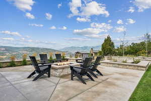 View of patio with a mountain view and an outdoor fire pit