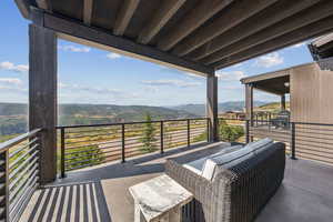 Balcony featuring a mountain view and a sunroom