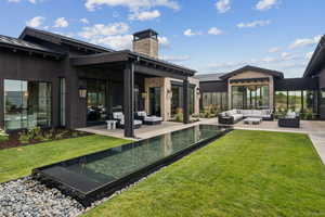 Rear view of property with outdoor lounge area, a patio area, a metal roof, and a standing seam roof