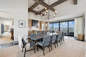 Dining room with beamed ceiling, coffered ceiling, a mountain view, light wood-type flooring, and a chandelier