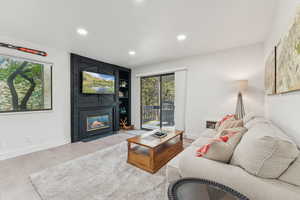 Living area with a fireplace, recessed lighting, and wood finished floors