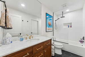 Full bathroom with a combined bath / shower with rainfall shower, vanity, and dark tile patterned floors