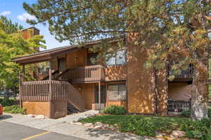 View of front of house featuring stairway, a balcony, and a chimney
