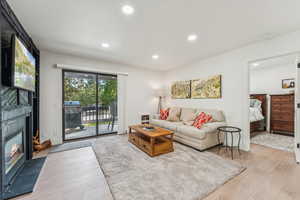 Living room with recessed lighting, light wood-style floors, and a fireplace