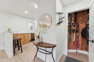 Corridor featuring light wood finished floors and recessed lighting
