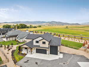 View of front of house with stone siding, concrete driveway, board and batten siding, and a mountain view
