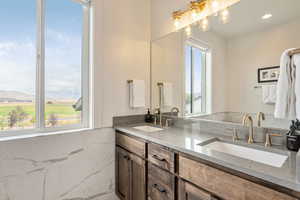 Bathroom with double vanity, recessed lighting, and wainscoting