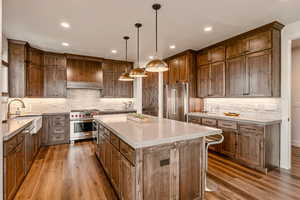 Kitchen featuring a center island, light wood-type flooring, light stone countertops, and recessed lighting