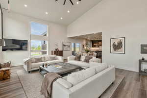 Living room featuring high vaulted ceiling, recessed lighting, and wood finished floors