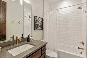 Bathroom with shower / bath combination with curtain and vanity