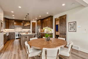 Dining space with light wood finished floors and recessed lighting