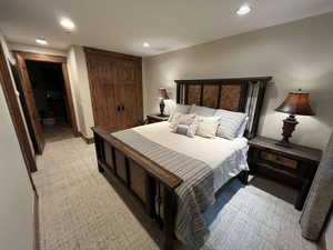 Bedroom with a closet, recessed lighting, and light carpet